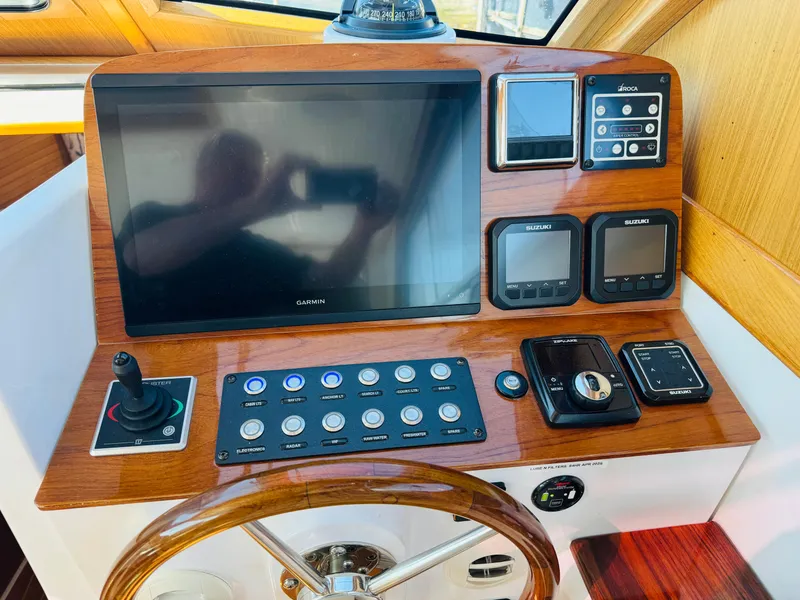 Slide: The Image of 2024 True North 34 Outboard Express helm with Garmin display and control panel. - 22