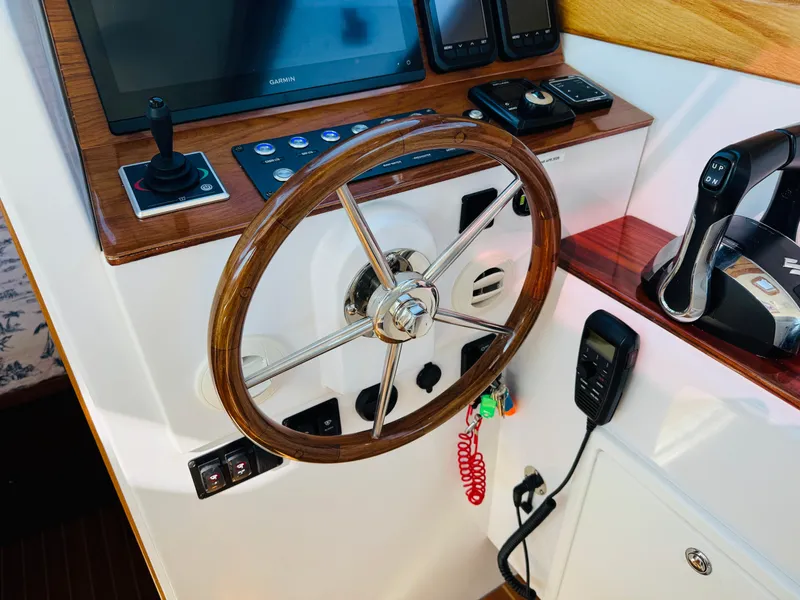 Slide: The Image of Helm of 2024 True North 34 Outboard Express with wooden steering wheel and modern controls. - 23