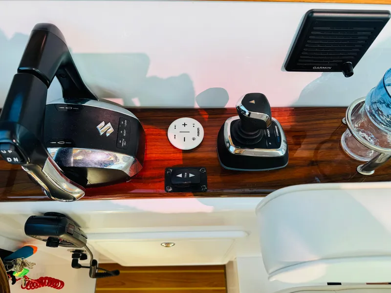 Slide: The Image of Control panel of 2024 True North 34 Outboard Express with Suzuki throttle and Garmin display. - 24