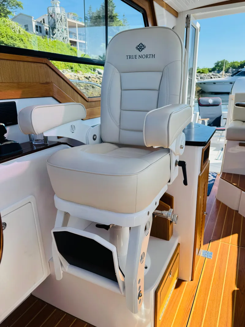 Slide: The Image of Captain's chair on 2024 True North 34 Outboard Express boat, featuring luxurious white upholstery. - 25