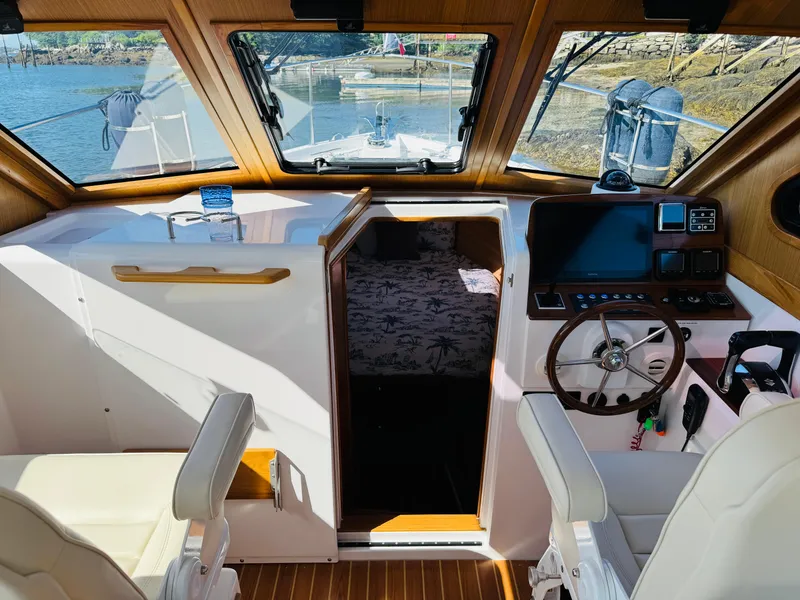 Slide: The Image of 2024 True North 34 Outboard Express cabin with helm, seating, and cozy interior. - 27