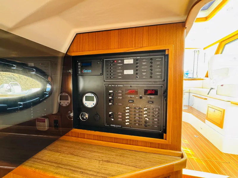 Slide: The Image of Electrical panel inside 2024 True North 34 Outboard Express boat, featuring modern controls and wood finish. - 28