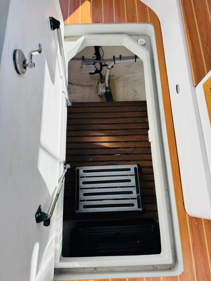 Slide: The Image of Hatch interior of 2024 True North 34 Outboard Express with wooden flooring and equipment. - 34
