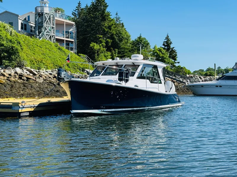 Slide: The Image of 2024 True North 34 Outboard Express boat docked in scenic marina setting. - 35