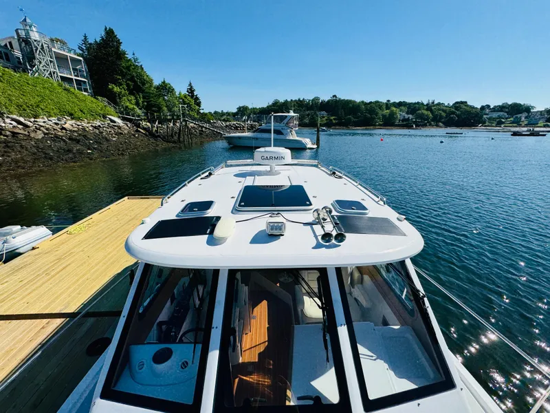 Slide: The Image of 2024 True North 34 Outboard Express docked in a scenic harbor. - 37