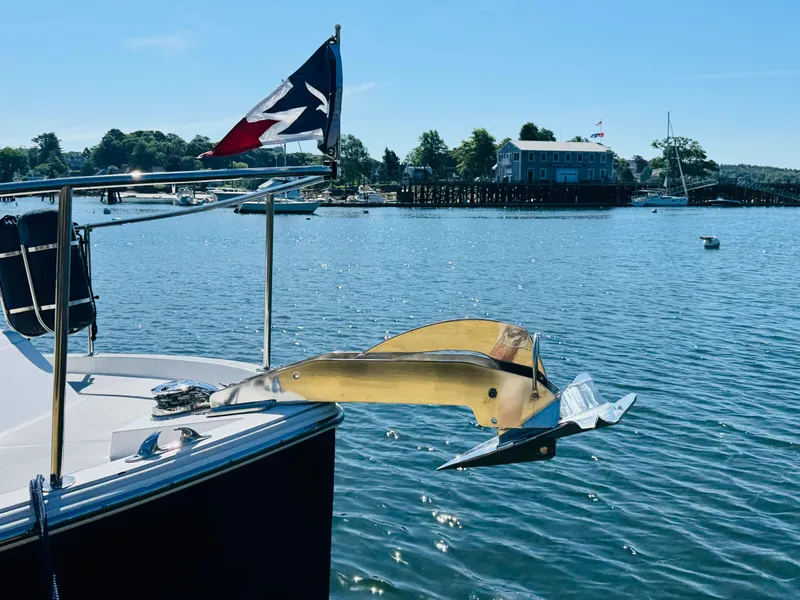 Slide: The Image of 2024 True North 34 Outboard Express anchored in scenic harbor with flag and anchor. - 38