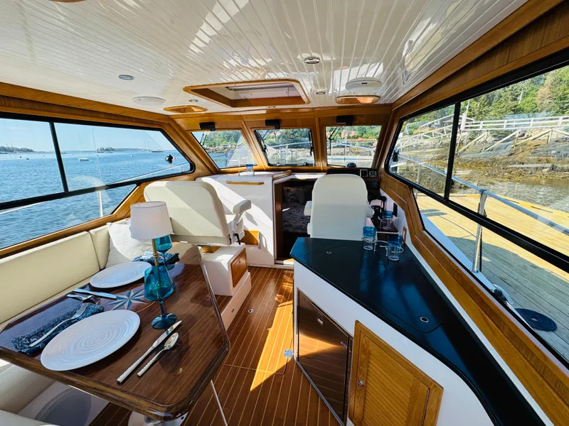 Slide: The Image of Interior of 2024 True North 34 Outboard Express yacht with elegant dining setup. - 5
