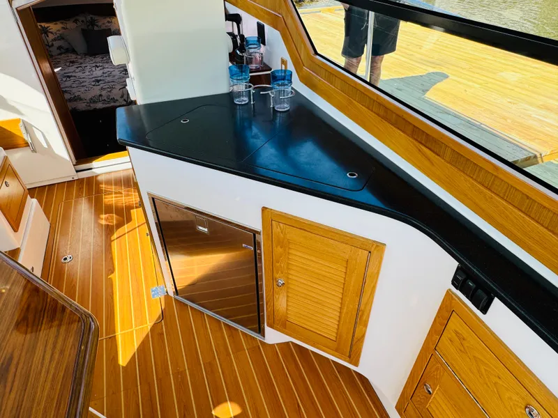 Slide: The Image of Interior of 2024 True North 34 Outboard Express with wood flooring and modern kitchenette. - 7