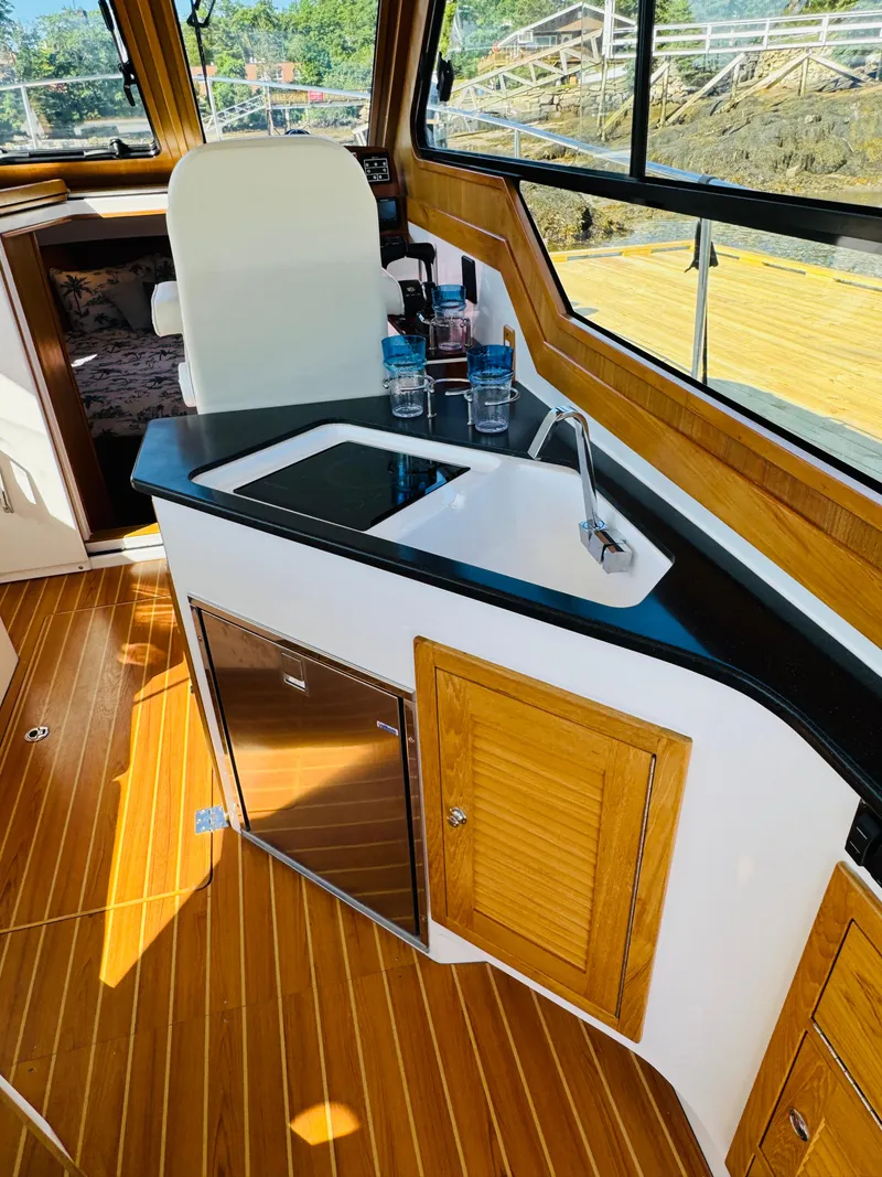 Slide: The Image of Interior of 2024 True North 34 Outboard Express with kitchenette and wooden flooring. - 8
