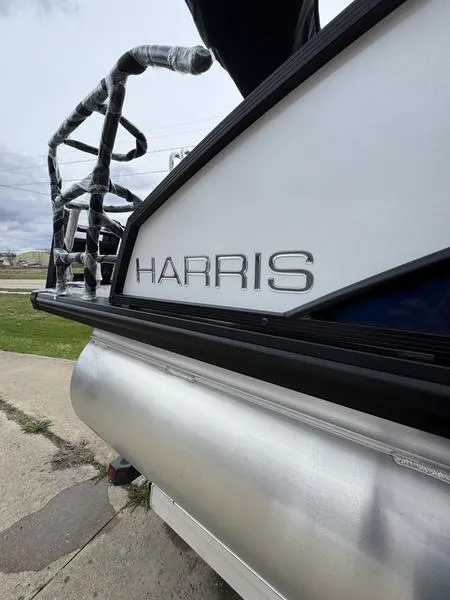 Slide: The Image of 2025 Harris Cruiser 230 pontoon boat, side view with logo and railing details. - 4