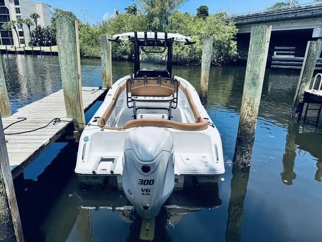 Slide: The Image of 2024 Sea Hunt Ultra 239 SE boat docked in a serene marina setting. - 11