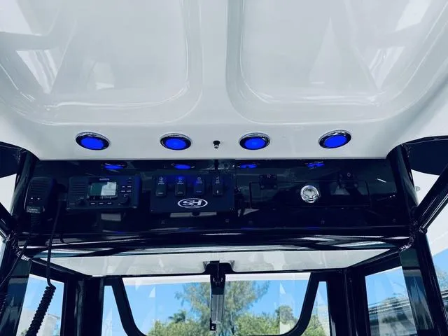 Slide: The Image of 2024 Sea Hunt Ultra 239 SE boat console with blue LED lights and control panel. - 28