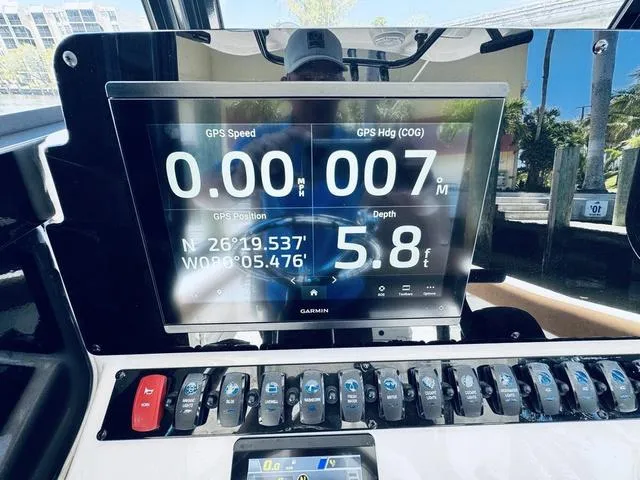 Slide: The Image of 2024 Sea Hunt Ultra 239 SE dashboard with Garmin GPS display showing speed, heading, and depth. - 32