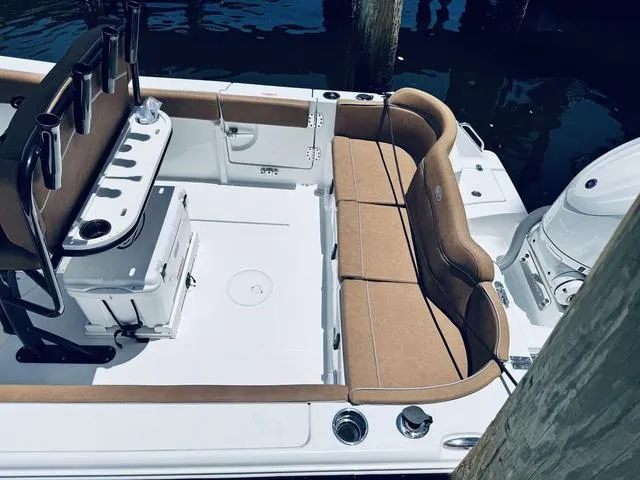 Slide: The Image of 2024 Sea Hunt Ultra 239 SE boat interior with tan seating and fishing rod holders. - 7