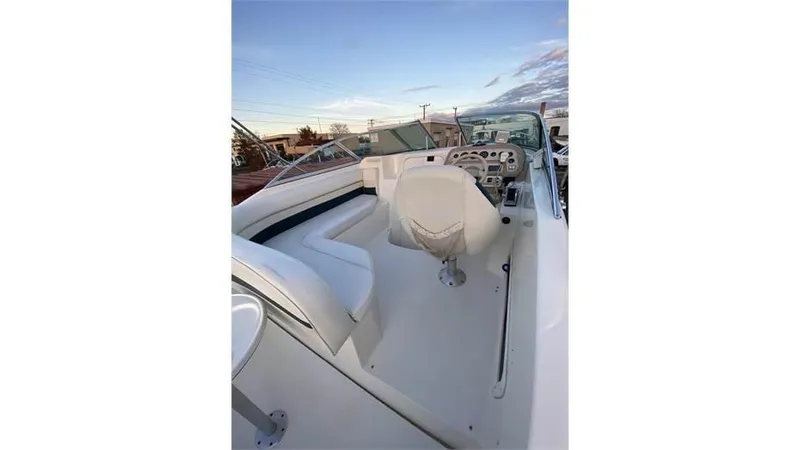 Slide: The Image of 1997 Rinker 266 Fiesta Vee boat interior with white seating and control panel. - 10