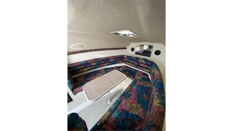 Slide: The Image of Interior of 1997 Rinker 266 Fiesta Vee boat with colorful seating and table. - 16
