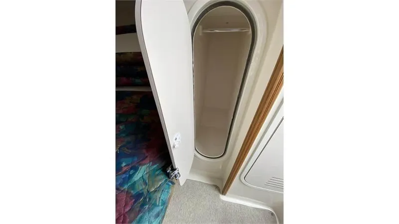 Slide: The Image of Interior of 1997 Rinker 266 Fiesta Vee boat showing cabin door and colorful bedding. - 18