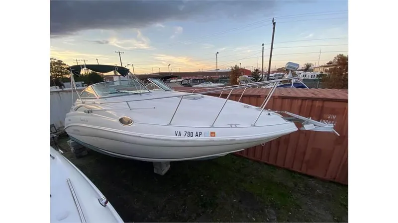 Slide: The Image of 1997 Rinker 266 Fiesta Vee boat on land, sunset background, storage area. - 4