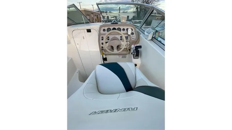 Slide: The Image of 1997 Rinker 266 Fiesta Vee boat cockpit with steering wheel and dashboard controls. - 7