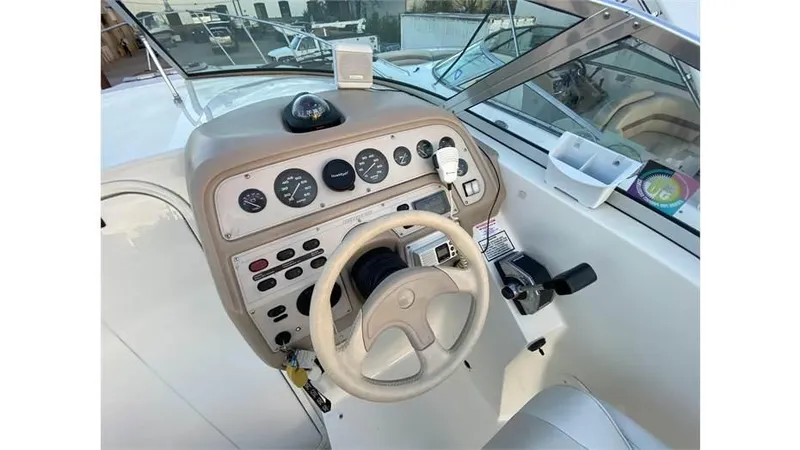 Slide: The Image of 1997 Rinker 266 Fiesta Vee boat dashboard with steering wheel and control panel. - 8