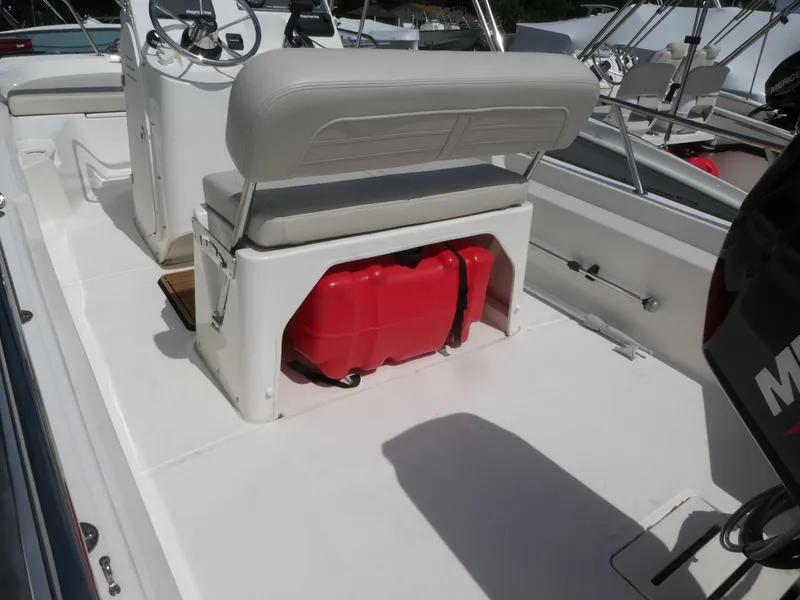 Slide: The Image of 2022 Boston Whaler 150 Montauk boat interior with seating and red fuel tank. - 4
