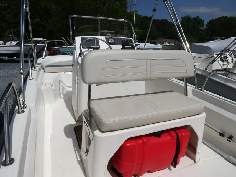 Slide: The Image of 2022 Boston Whaler 150 Montauk boat interior with seating and red storage. - 5