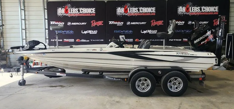 Slide: The Image of 2016 Triton 20 TRX boat on trailer in showroom with branded backdrop. - 1