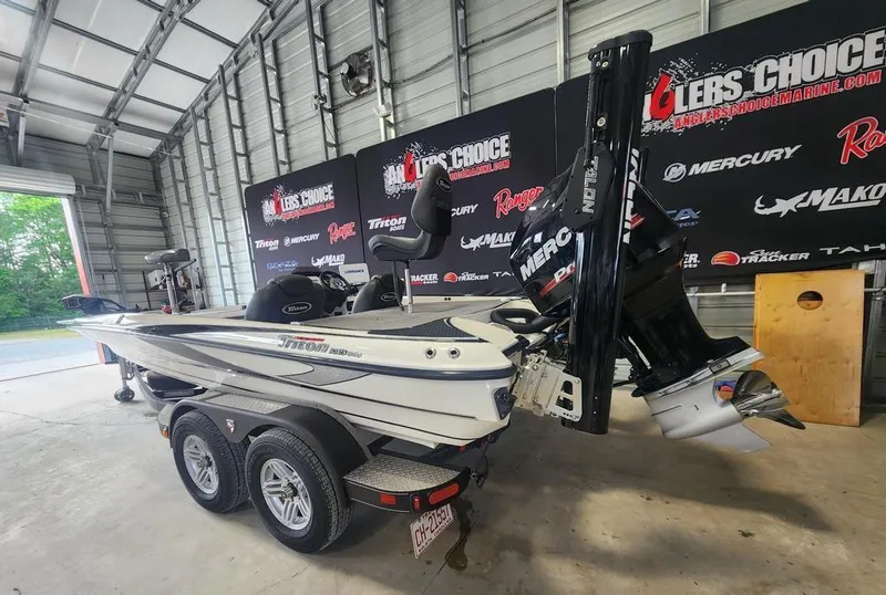 Slide: The Image of 2016 Triton 20 TRX boat in garage, featuring dual axle trailer and Mercury engine. - 3