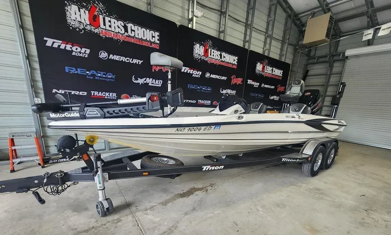 Slide: The Image of 2016 Triton 20 TRX boat on trailer in garage, Angler's Choice backdrop. - 5