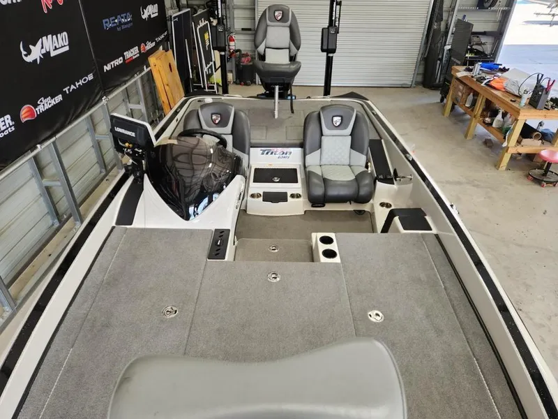 Slide: The Image of 2016 Triton 20 TRX boat interior with seating and storage in a garage setting. - 6