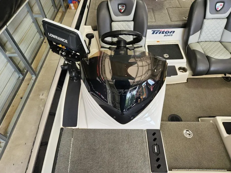 Slide: The Image of 2016 Triton 20 TRX boat interior with steering wheel and Lowrance fishfinder. - 7