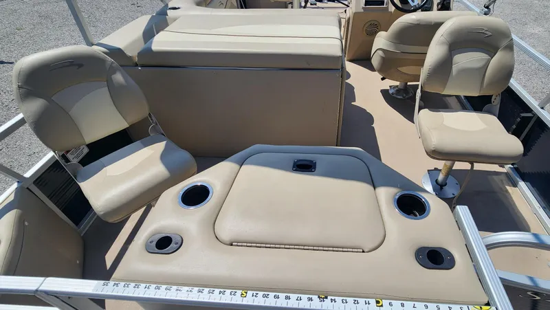 Slide: The Image of 2014 Bennington 20 SF boat interior with beige seating and cup holders. - 8