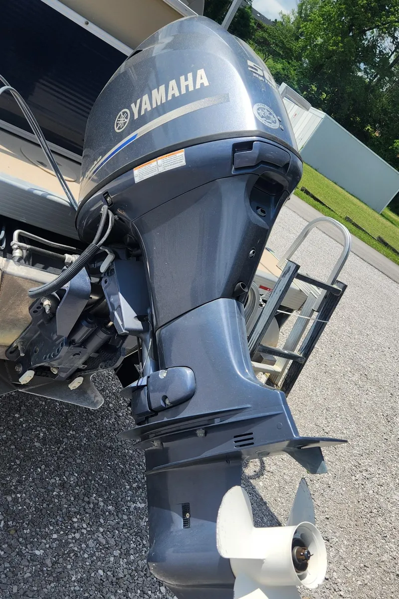 Slide: The Image of 2014 Bennington 20 SF with Yamaha outboard motor, parked on gravel. - 9