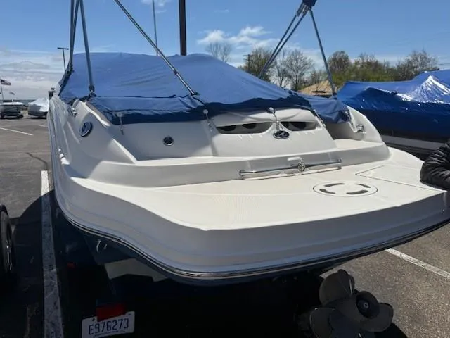 Slide: The Image of 2006 Sea Ray 220 Sundeck boat with blue cover in parking lot. - 10