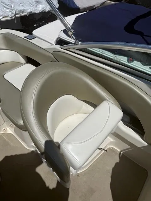 Slide: The Image of 2006 Sea Ray 220 Sundeck boat interior with beige seating and steering wheel. - 18