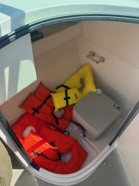 Slide: The Image of Storage compartment in 2006 Sea Ray 220 Sundeck with life jackets and portable toilet. - 22