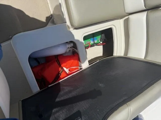 Slide: The Image of 2006 Sea Ray 220 Sundeck storage compartment with life jackets and equipment. - 24