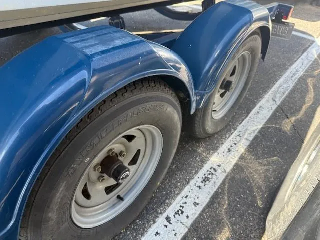 Slide: The Image of Trailer wheels of a 2006 Sea Ray 220 Sundeck boat, parked on asphalt. - 30