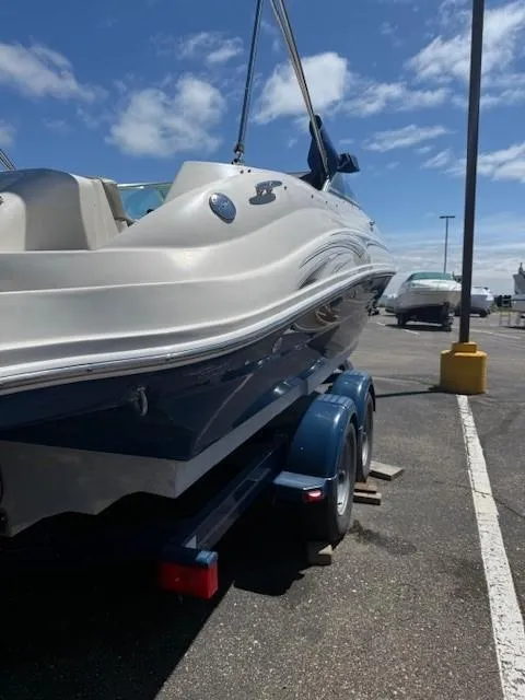 Slide: The Image of 2006 Sea Ray 220 Sundeck on trailer in parking lot under blue sky. - 7