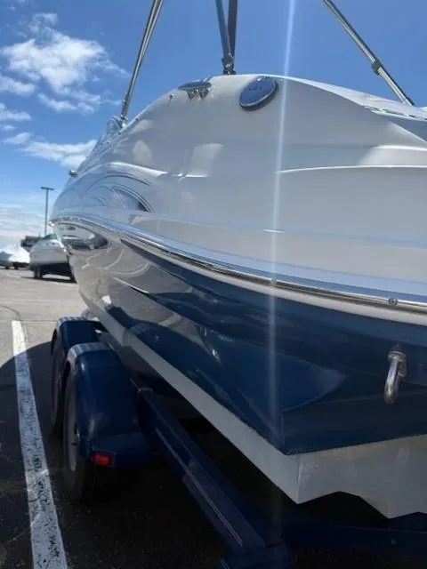 Slide: The Image of 2006 Sea Ray 220 Sundeck boat on trailer under blue sky. - 8