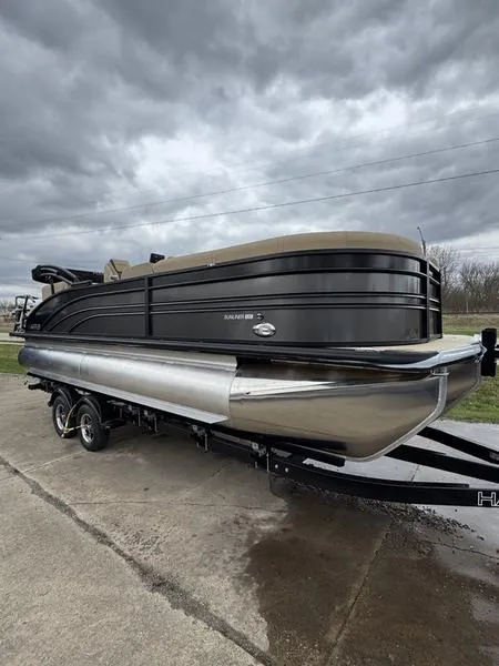 Slide: The Image of 2025 Harris Sunliner 230 pontoon boat on trailer under cloudy sky. - 1