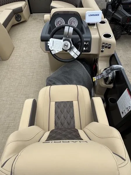 Slide: The Image of 2025 Harris Sunliner 230 boat interior with steering wheel and beige seating. - 11