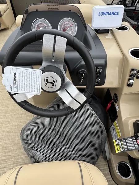 Slide: The Image of 2025 Harris Sunliner 230 boat dashboard with steering wheel and Lowrance navigation system. - 12