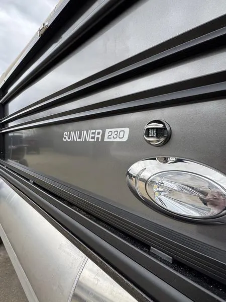 Slide: The Image of 2025 Harris Sunliner 230 pontoon boat, sleek design with modern detailing. - 4