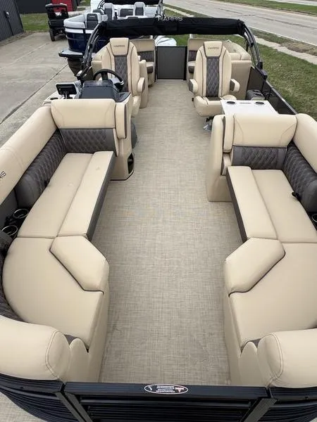 Slide: The Image of 2025 Harris Sunliner 230 pontoon boat with spacious beige seating and modern design. - 6