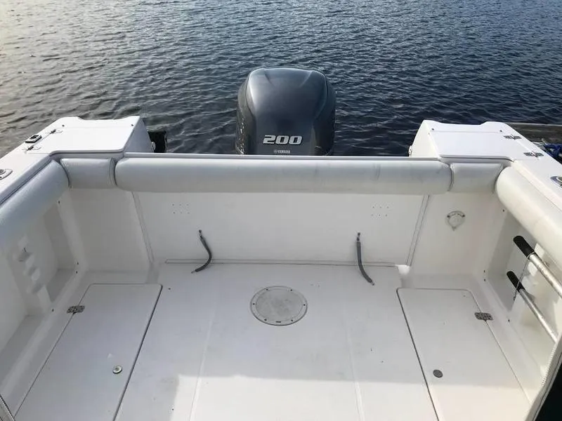 Slide: The Image of 1998 Wellcraft 23 Walkaround boat with Yamaha 200 engine, spacious deck, and water backdrop. - 1