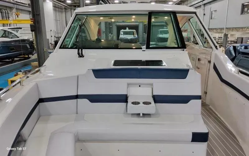 Slide: The Image of 2025 Formula 400 Super Sport Crossover boat interior with seating and cup holders in a showroom. - 25