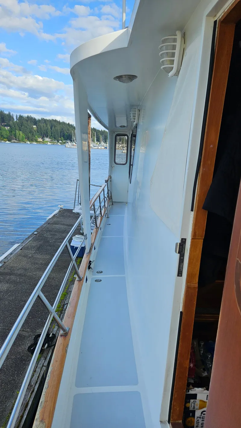 Slide: The Image of 1987 DeFever 53 POC yacht deck with chairs, overlooking calm waters and distant shoreline. - 11