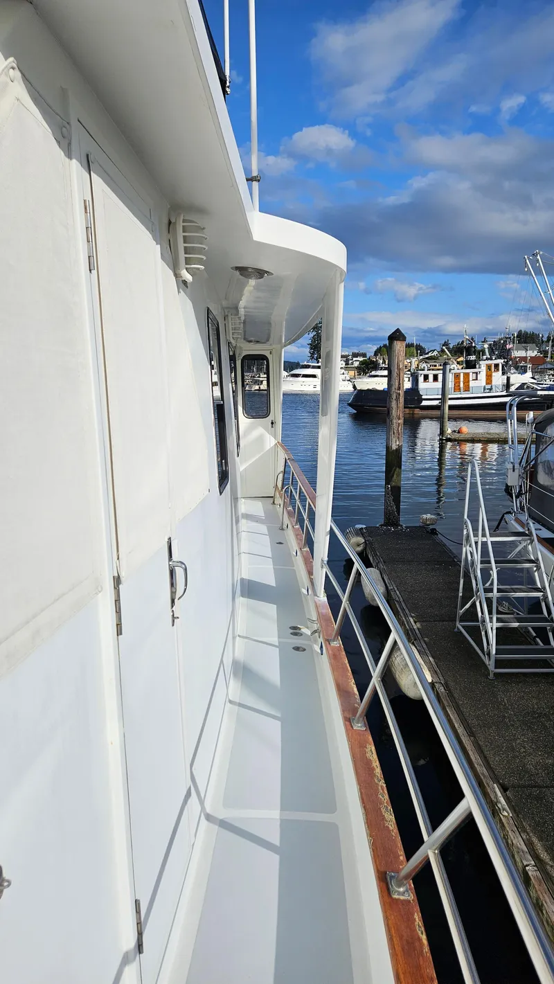 Slide: The Image of Interior view of 1987 DeFever 53 POC yacht with striped seating and ocean backdrop. - 12