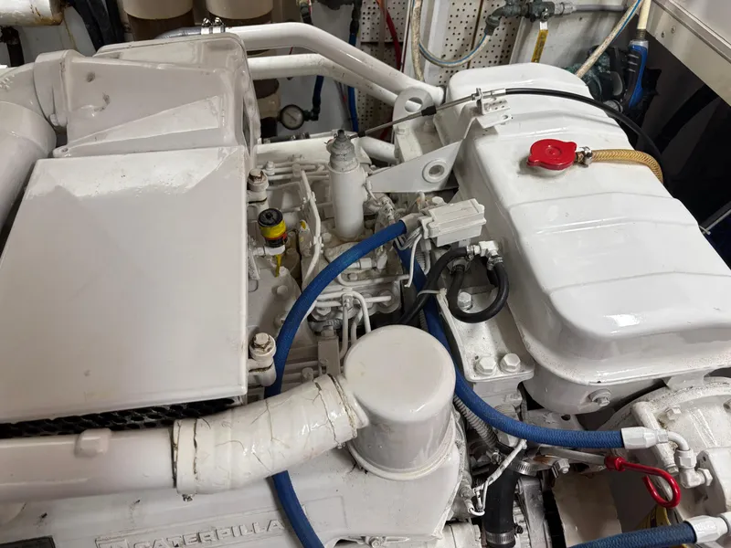 Slide: The Image of Engine room of 1987 DeFever 53 POC yacht, featuring mechanical components and hoses. - 28